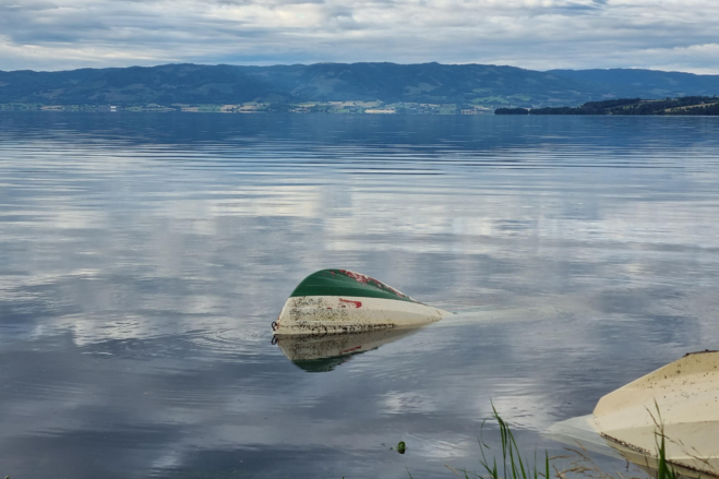 Veltet båt ligger opp ned i vannet etter ekstremnedbør og flom
